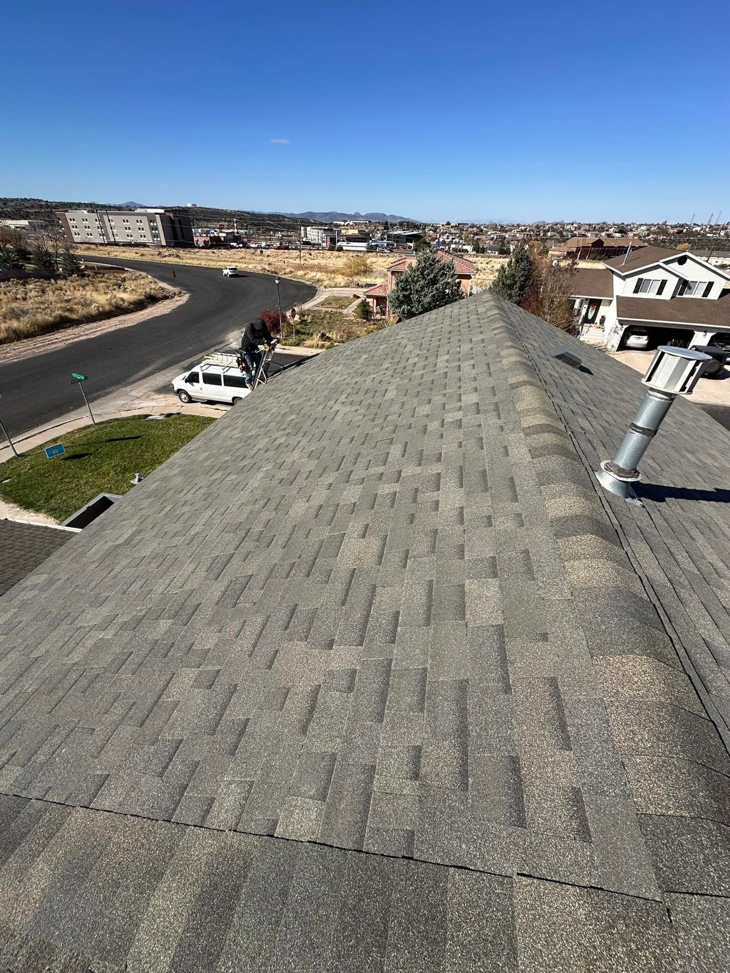 Freshly installed gray shingle roof overlooking a Southern Utah subdivision and mountains