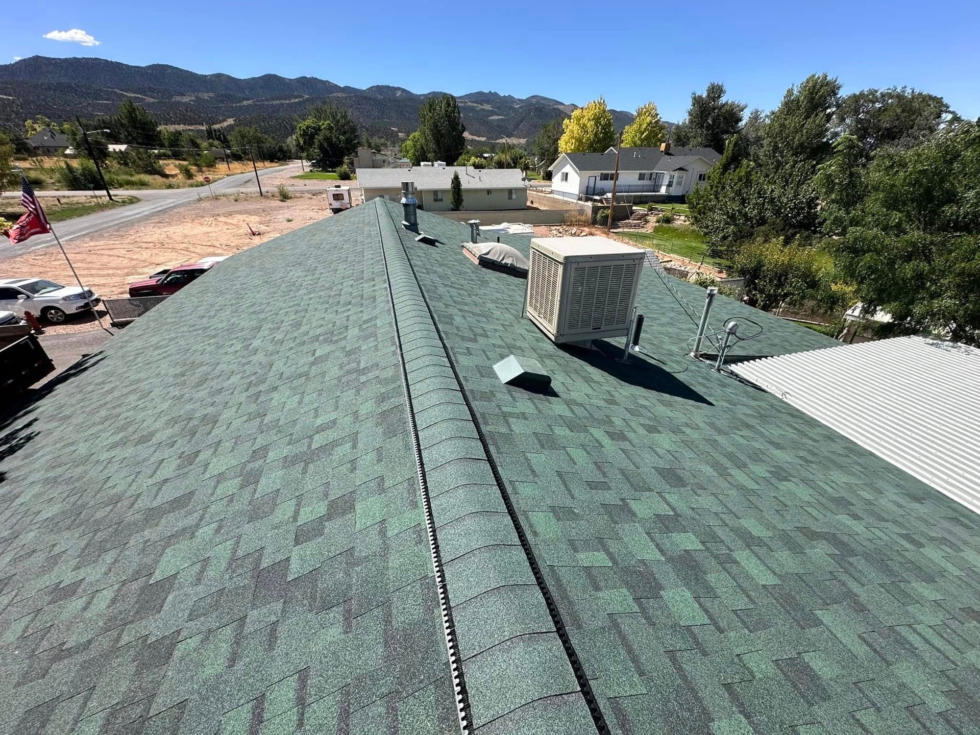 Wide view of a new shingle roof ridge with Southern Utah mountains in the background
